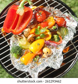 Healthy Organic Vegetarian And Vegan Cuisine With An Assortment Of Farm Fresh Vegetables Grilling In Tin Foil Over The Heat Of A Barbecue Fire