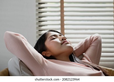 Healthy Peaceful Lady Relaxing On Comfy Sofa Dozing Feel Worry Free At Home Lounge Alone, Taking Deep Breaths Of Fresh Air While Holding Hands Behind Head.