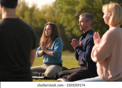 Healthy people doing yoga at park. Group of multiethnic people exercising on green grass with yoga mat.  - Shutterstock ID 1503359174