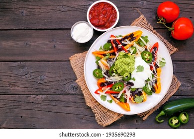 Healthy, Plant Based Bell Pepper Nachos. Overhead View Table Scene On A Dark Wood Background. Low Carb, Vegetarian Diet.