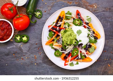 Healthy, Plant Based Bell Pepper Nachos. Above View Table Scene On A Dark Slate Background. Low Carb, Vegan Diet.