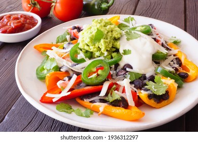 Healthy, Plant Based Bell Pepper Nachos. Close Up Table Scene On A Dark Wood Background.