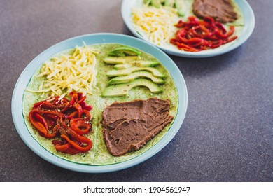 Healthy Plant-based Food Recipes Concept, Vegan Version Fo The Viral Layered Tortilla Wrap Hack With Red Peppers Grated Dairy-free Cheese Avocado And Refried Beans