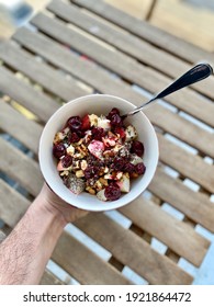 Healthy Porridge With Sour Cherry Jam, Chia Seeds, Walnut  And Apple Holding In Hand For Breakfast.