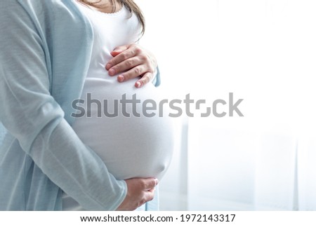 Image, Stock Photo Pregnant woman holding her tummy