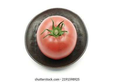 Healthy Raspberry Tomato With Very Thin Skin And Juicy Flesh. Red Tomato On Handmade Rustic Plate. Round Vegetable And A Small Saucer On White Background.