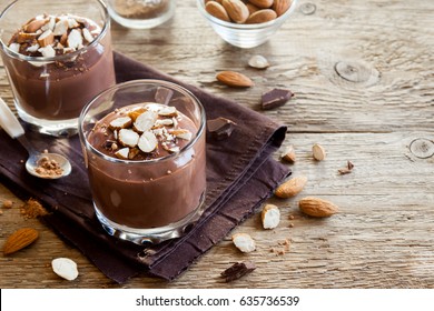 Healthy Raw Vegan Chocolate Mousse Topped With Almond In Glasses Over Wooden Background Close Up - Delicious Homemade Raw Vegan Chocolate Pudding With Nuts And Carob Powder