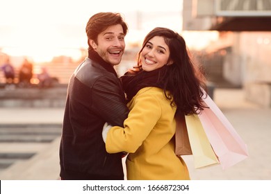 Healthy Relationship. Portrait Of Beautiful Couple With Paper Bags Looking Back At Camera Over The Shoulder