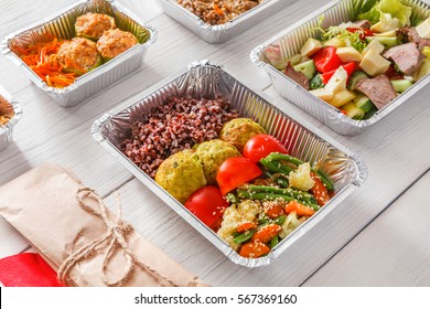 Healthy Restaurant Food. Chef Prepared Diet Daily Meals Delivery. Fitness Nutrition, Vegetables, Meat And Fruits In Foil Boxes, Cutlery In Craft Package On Wood