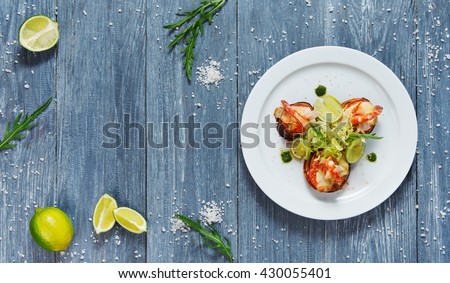 Healthy restaurant food. Ratatoille with cheese and shrimp top view, flat lay with copyspace at blue rustic wood background. Seafood vegetarian carpaccio. Healthy food, restaurant french cuisine.