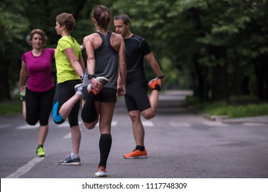 healthy runners team warming up and stretching in city park before morning training - Powered by Shutterstock