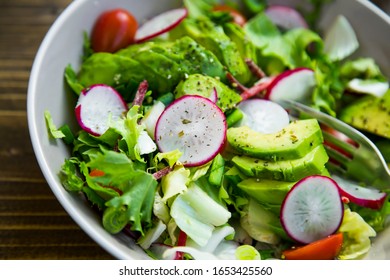 Healthy salad closeup. Clean eating , vegan vegetarian healthy salad with radish, beetroot, lettuce, cherry tomatoes, avocado, green onion and spices - Powered by Shutterstock