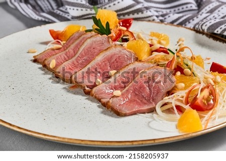 Healthy salad with duck meat, orange and vegetables. Chinese food - duck salad with citrus and fresh dressing. Sliced duck meat with crispy vegetables and pine nuts