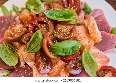 Healthy Salad With Raw Salmon, Tuna, Green Salad, Tomato, Basil And Sesame Seeds