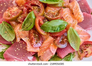 Healthy Salad With Raw Salmon, Tuna, Green Salad, Tomato, Basil And Sesame Seeds