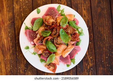 Healthy Salad With Raw Salmon, Tuna, Green Salad, Tomato, Basil And Sesame Seeds