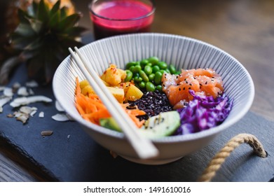 Healthy Salmon Poke Bowl, Fresh Food And Raw Ingredients. Poke Bowl Made With Edamame Beans, Pineapple, Carrots, Slaw And Black Rice