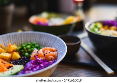 Healthy Salmon Poke Bowl, Fresh Food And Raw Ingredients. Poke Bowl Made With Edamame Beans, Pineapple, Carrots, Slaw And Black Rice