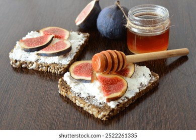 a healthy sandwich with curd cheese, a fig and honey next to a jar of honey - Powered by Shutterstock