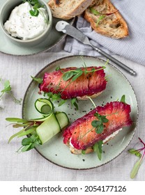 Healthy Sandwiches With Sourdough Crisp Bread Slices, Sour Cream, Beetroot Cured Salmon And Cucumber On Green Ceramic Plate, Top View
