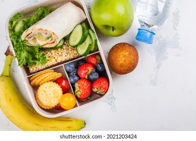 Healthy school lunch box with roll, apple and muffin. Copy space. Top view