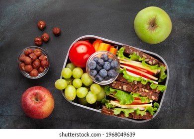 Healthy School Lunch Box With Sandwich And Fresh Vegetables, Water Bottle, Nuts And Fruits. Top View Flat Lay