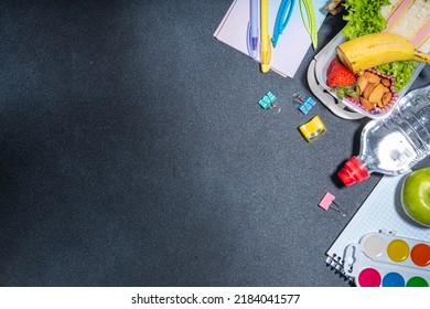 Healthy School Lunch Box: Sandwich, Vegetables, Fruit, Nuts And Yogurt With School Kids Supplies, Accessories And Backpack On Black Background Flatlay Copy Space. Back To School Concept