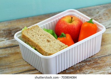 Healthy School Lunchbox  Containing Brown Cheese Sandwich, Crunchy Yellow Pepper And Red Apple
