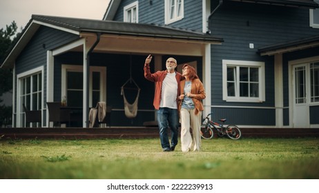 Healthy Senior Couple Walking Outdoors Their Residential Area Home, Embracing Each Other. Loving Adults, Talk, Have Fun, Point to the Distance and Enjoy Their Happy Retirement Life. - Powered by Shutterstock