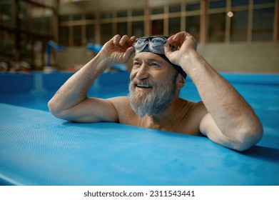 Healthy senior man swimming in indoor pool enjoying sportive lifestyle - Powered by Shutterstock