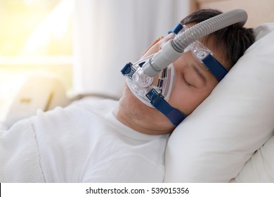  
Healthy Senior Man Wearing Cpap Mask Sleeping Smoothly All Night On His Back Without Snoring,side View With Backlit.Obstructive Sleep Apnea Therapy.