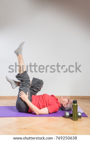 Healthy senior woman doing pilates or yoga, keeping herself relaxed and healthy