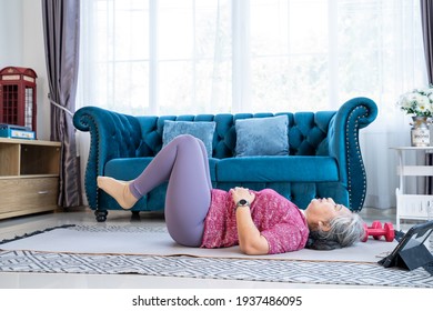 Healthy Senior Woman Lie On The Floor And Raise Two Leg Up While Doing Exercise Stretching Legs With Lying Leg Lift, Workout Fitness Pose At Home