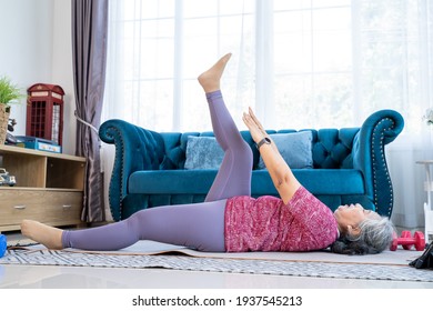 Healthy Senior Woman Lie On The Floor While Doing Exercise Stretching Legs With Lying Leg Lift, Workout Fitness Pose At Home