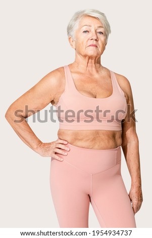 Healthy senior woman in pink sports bra and leggings