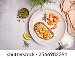 Healthy shrimp sandwiches for breakfast, snack, appetizers Toast with grilled prawns and whole grain bread with cream cheese and arugula on a light background, top view