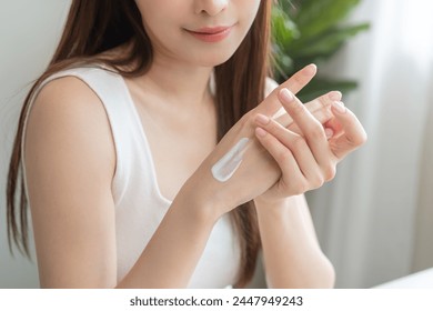 Healthy skin care, beauty asian young woman hand applying moisturizer, putting cream treatment on back hand after shower bath at home, makeup routine in the morning, treatment skin care body concept. - Powered by Shutterstock