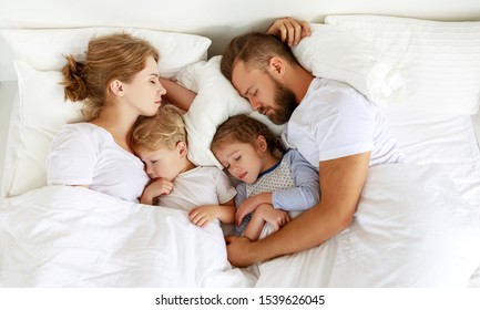 healthy sleep. happy family parents and children sleeping in white bed at home