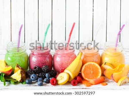 Healthy smoothies with fresh ingredients on a kitchen board.