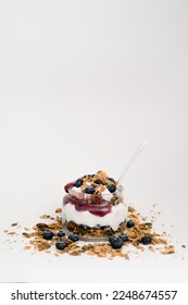 Healthy Snack Lifestyle Image. Yogurt parfait with granola, blueberry preserves and fresh blueberries. Vertical image with negative copy space above.