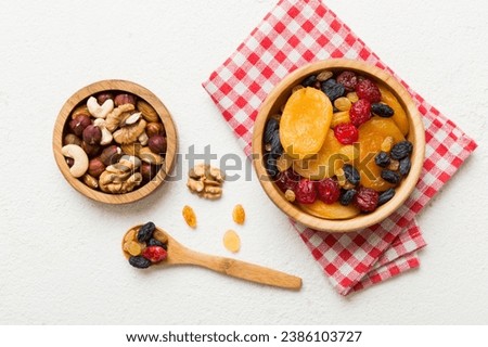 healthy snack: mixed nuts and dried fruits in bowl on table background, almond, pineapple, cranberry, cherry, apricot, cashew.