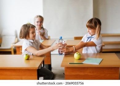 A Healthy Snack At School, Green Apples And Water At School Recess. Children Share Food In Class During The Break, Friendships And Relationships Of Classmates