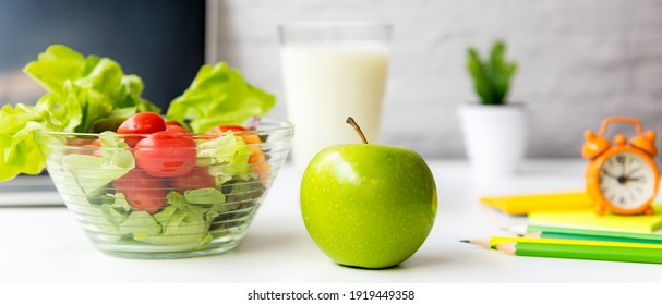 Gesunder Snack mit Arbeit im Büro.  Grüner Apfel und frischer Salat mit Wasser für Ernährung Gesundheitsplan mit Laptop auf weißem Kleid zu arbeiten.  Gesundes Lifestyle-Konzept, Kopienraum für Banner