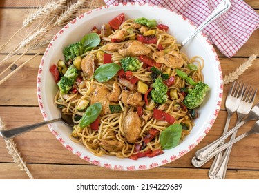 Healthy Spaghetti Dish With Chicken Breast And Mediterranean Vegetables In A Large Bowl Isolated On Wooden Table. Homemade Family Meal