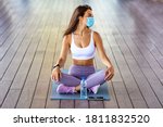 Healthy sports lifestyle. Athletic  woman in sports dress doing fitness exercise. Fitness woman streching Relaxing after training with protectve mask during Covid19. Exercising in the city with smog