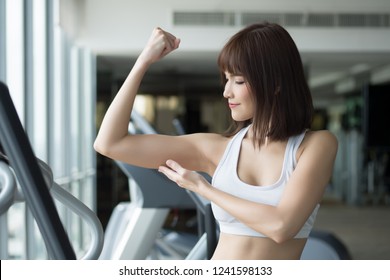 Healthy Strong Fitness Woman Works Out In Gym. Portrait Of Fitness Woman In Gym Posing For Strong Body And Arm, Gym Workout, Weight Training, Healthy Lifestyle Concept. Asian Adult Fitness Woman Model