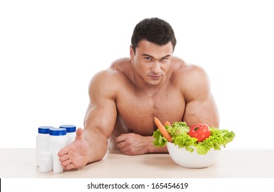 Healthy Strong Handsome Man Choosing Healthy Food Instead Of Steroid. Sitting Isolated On White Background 