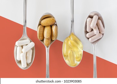 Healthy supplements on teaspoons against colorful background