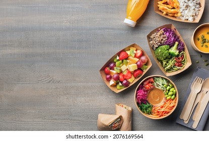 Healthy Take Away Food And Drink In Disposable Eco Friendly Paper Containers On Gray Wooden Background, Top View. Fresh Salad, Soup, Poke Bowl, Vegetable, Fruits, Chicken Wrap And Juice.