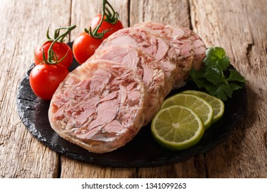 Healthy tasty food head cheese or brawn and fresh tomatoes, lime and cilantro closeup on a slate board on the table. horizontal
